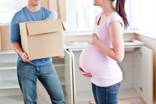 A pregnant woman and her husband in the middle of moving.