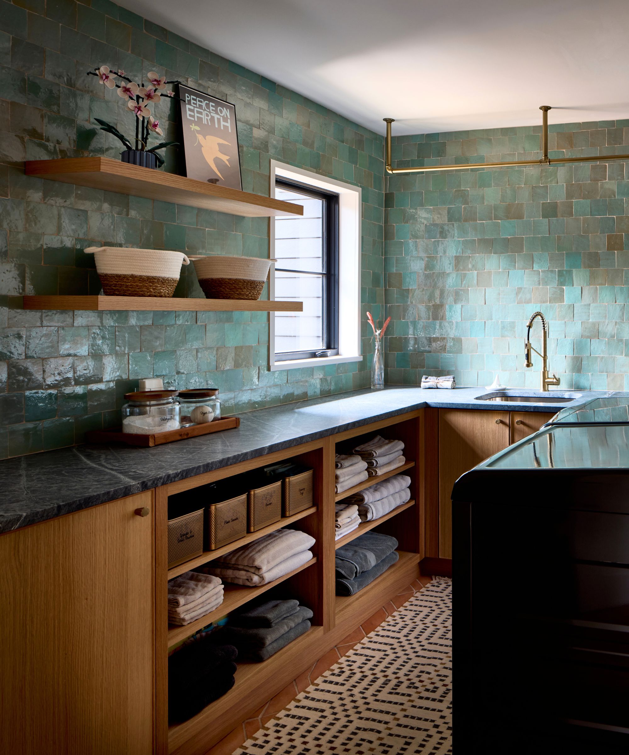 Four Brothers laundry room with zellige tiles from Zia Tile, white oak cabinetry and black soapstone countertop