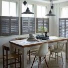 dinning room with blind and shutter hanging light and wooden table
