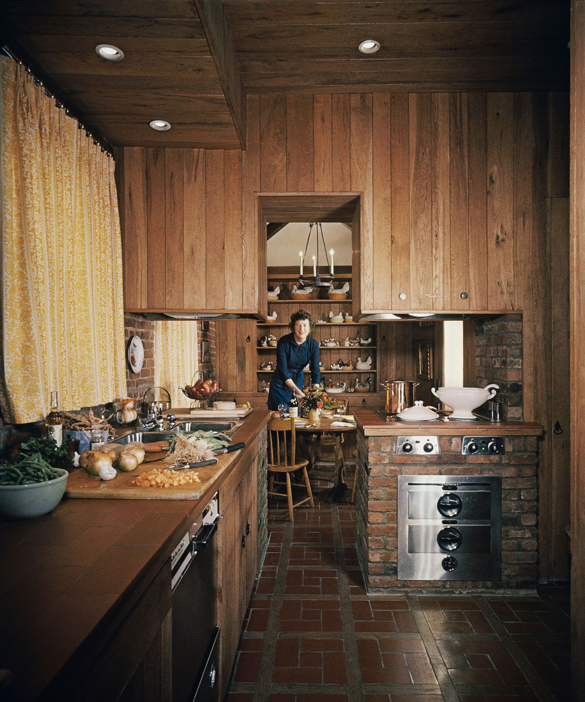 Julia Child in her wood panelled dining room and kitchen