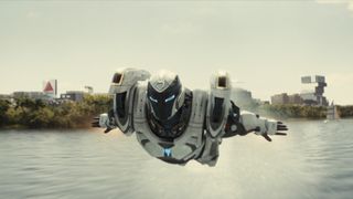 Riri Williams flying in her white supersuit over a river in Marvel's Ironheart TV show