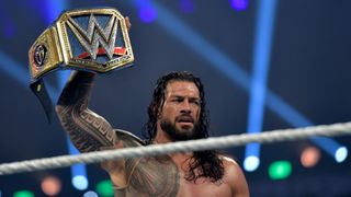 An exhausted Roman Reigns lifts a gold WWE wrestling belt aloft ahead of Royal Rumble 2023 on Saturday 28th January.