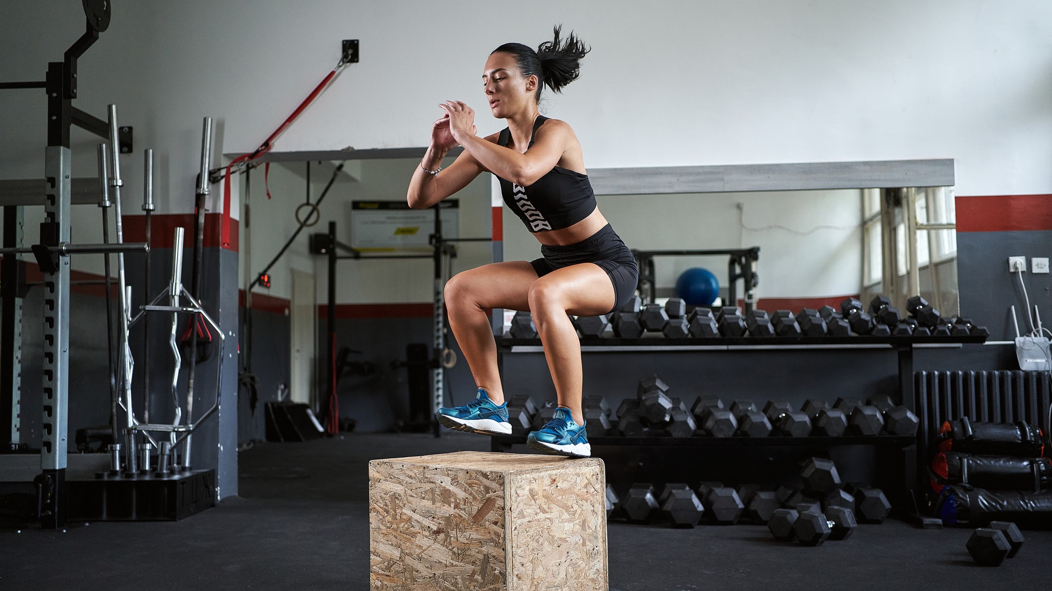 a photo of a woman doing box jumps