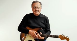 D'Addario CEO Jim D'Addario is photographed wearing a black long-sleeve sweatshirt and holds a Fender Stratocaster