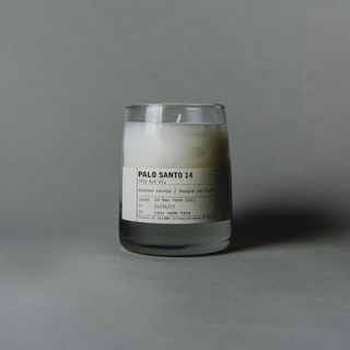 A candle against a grey background.