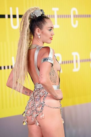 Miley Cyrus in an Atelier Versace-designed nude thong under a sparkly skirt