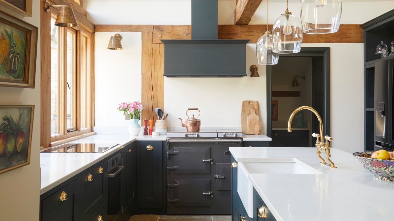 country kitchen ideas, country style farmhouse kitchen with beams, off white walls, dark grey units, white worktops, Everhot range, copper kettle, clear glass pendants, kitchen island with sink 