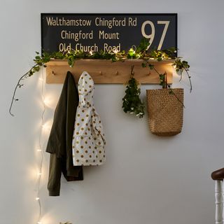 Hallway coat hooks decorated with ivy and fairy lights