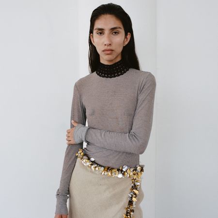 woman posing in a sheer top and an embellished skirt from Diotima's Spring 2025 collection 