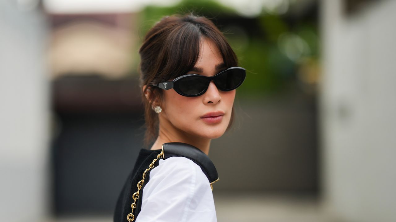 Heart Evangelista wears Prada sunglasses, a white shirt, during a street style fashion photo session, on November 18, 2023 in Manila, Philippines.