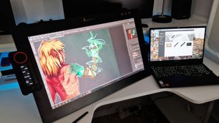 Best drawing tablets; a photos of the Xencelabs Pen Display 24 tablet on a desk with a Lenovo laptop