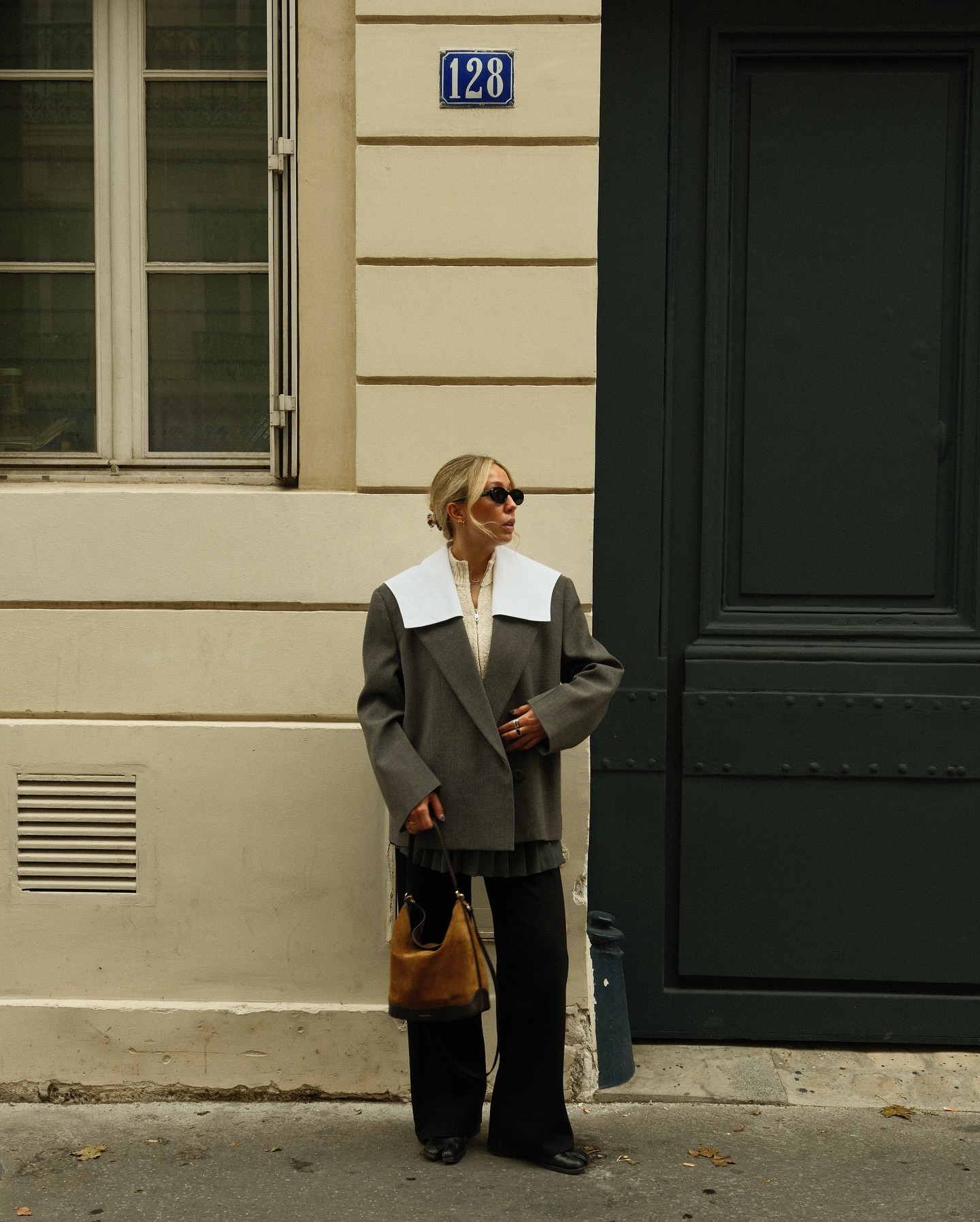 Fashion person Charlotte Illidge wears a winter knitwear trend. She wears a zip up cardigan, a grey blazer, grey skirt and black trousers in a recent image taken from Instagram.