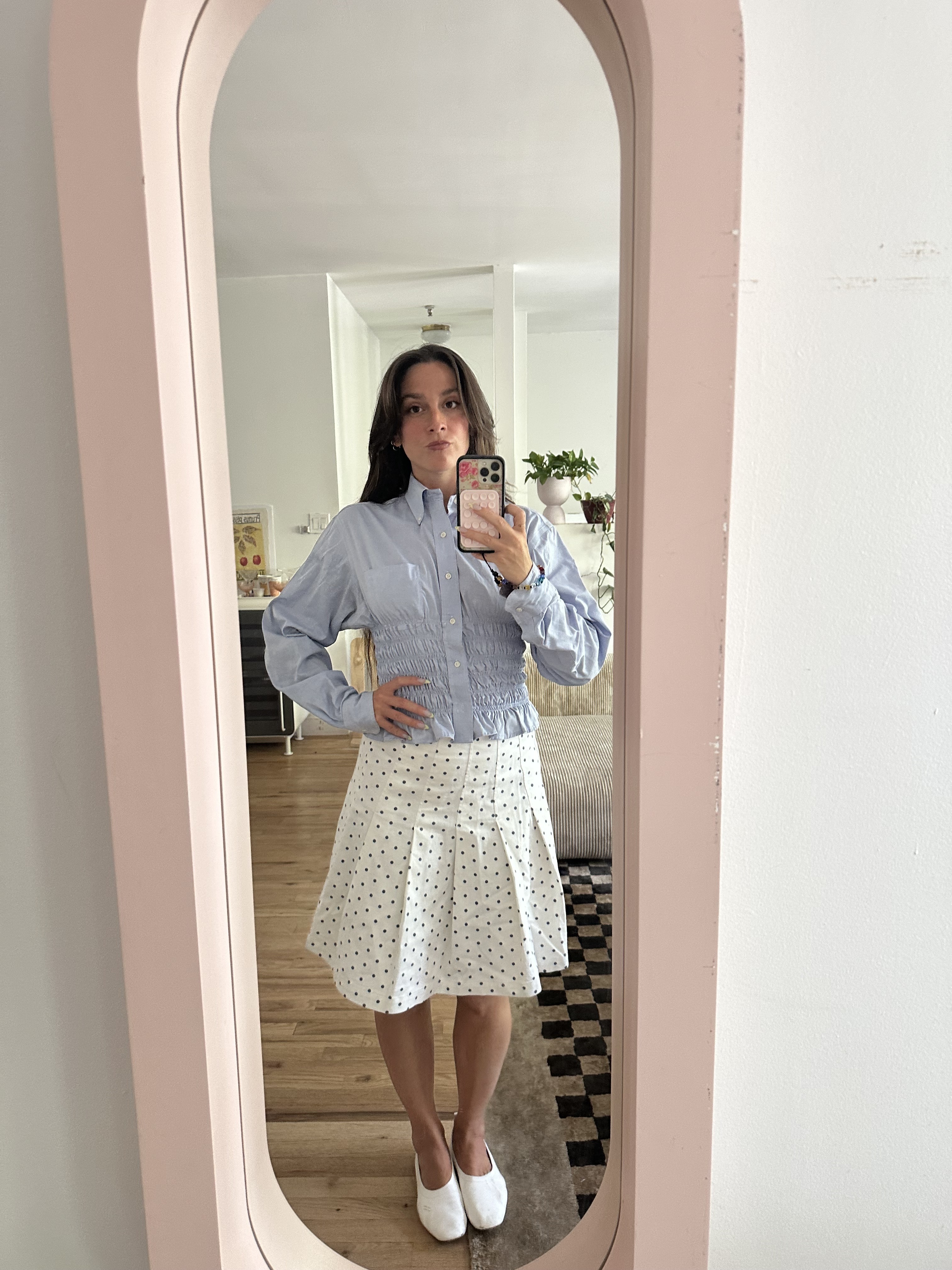 Tara Gonzalez taking selfies in a polka dot skirt.