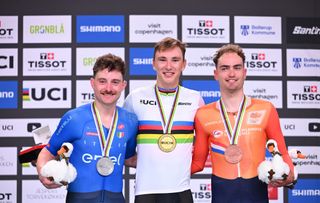 (L-R) Second placed Italy's Simone Consonni, winner Belgium's Lindsay de Vylder and third placed Netherlands' Yanne Dorenbos celebrate during the podium ceremony after the men's Omnium - Points Race 4/4 race of the UCI Track Cycling World Championships in Ballerup, Denmark, on October 19, 2024. (Photo by Jonathan NACKSTRAND / AFP)