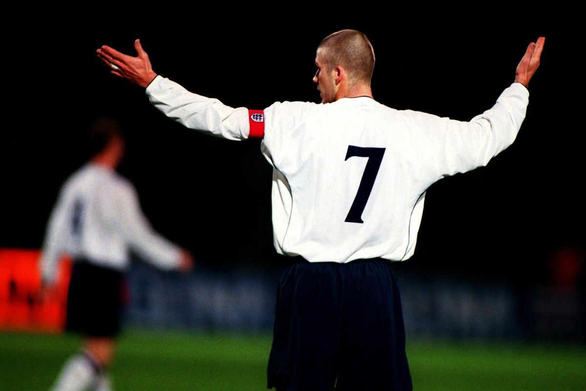 A photo taken from behind of David Beckham gesturing while playing for England against Albania, 2001