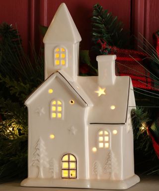 White Light Up House Decoration on a windowsill at Christmas