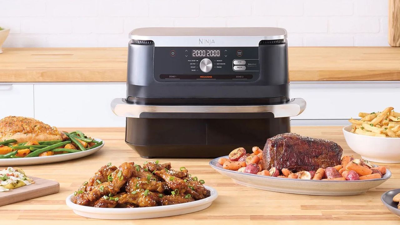 Do air fryers need to pre-heat? Ninja Foodi FlexBasket air fryer on a kitchen counter, surrounded by plates of air-fried food.