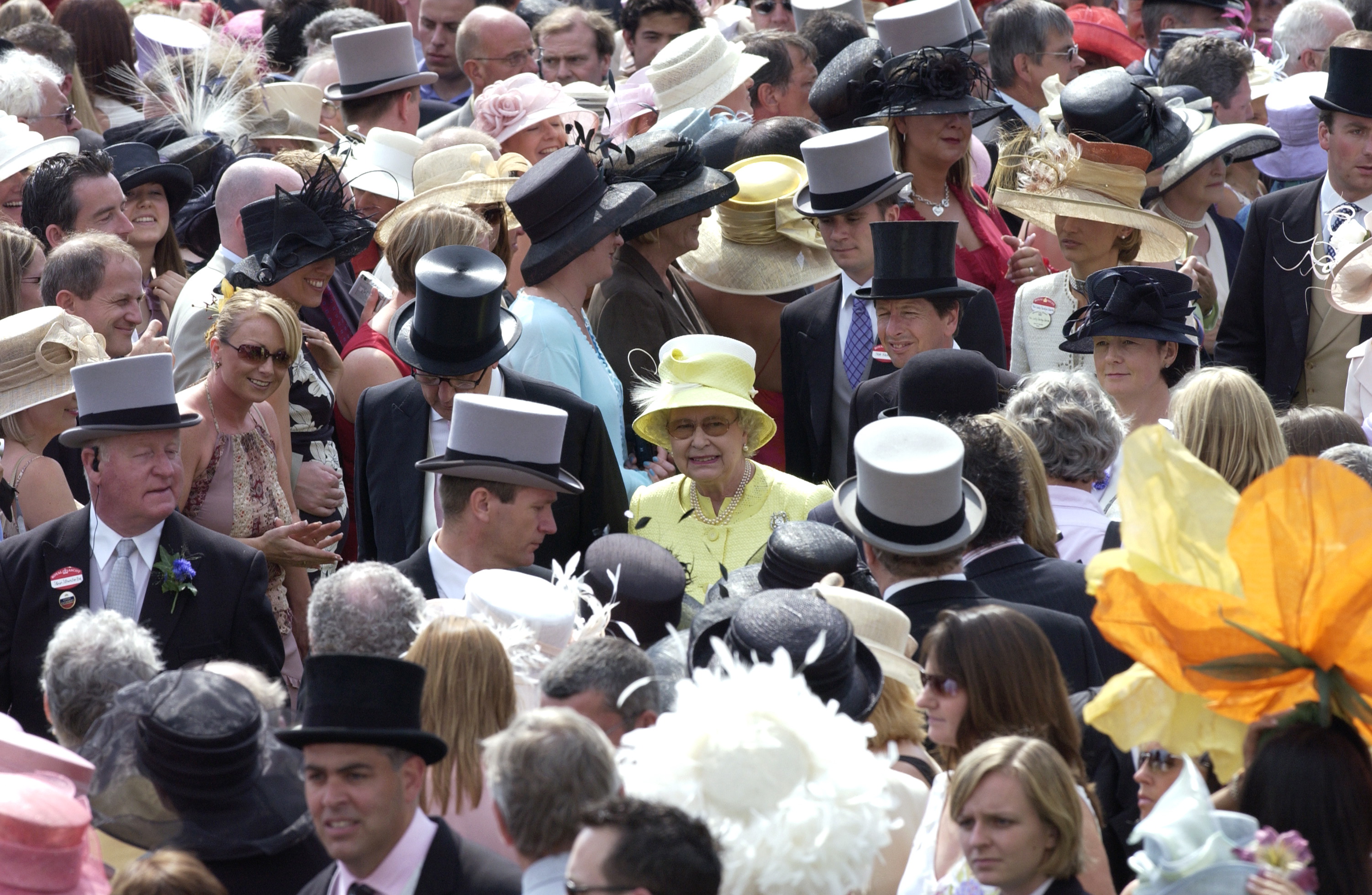 Queen Elizabeth standing in a crowd of people in a green coat