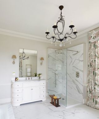 A large shower room with a white vanity unit, a chandelier and a marble shower
