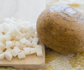 Whole and chopped jicama on a wooden board