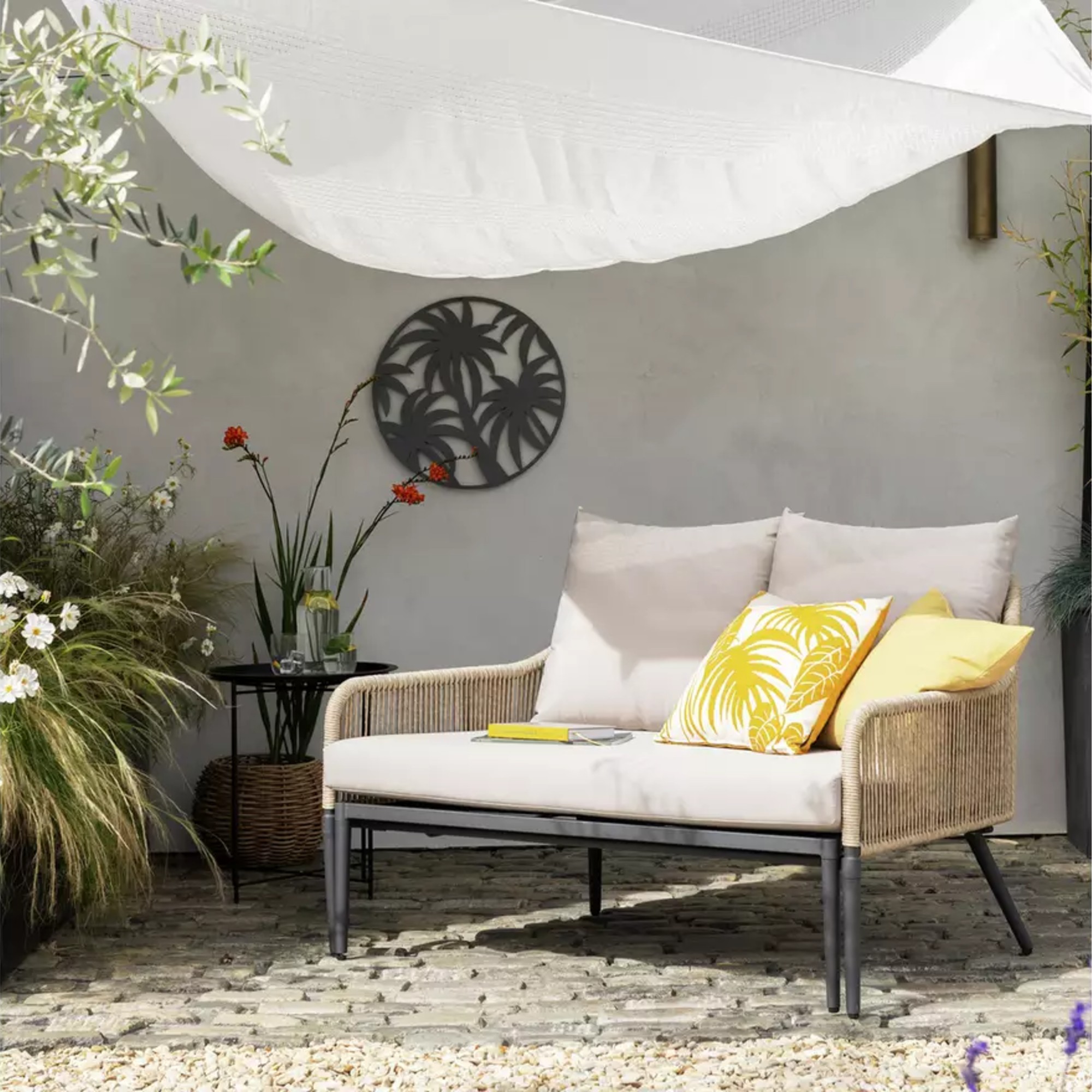 Habitat Malta Rattan Effect Garden Day Bed on a cobbled patio