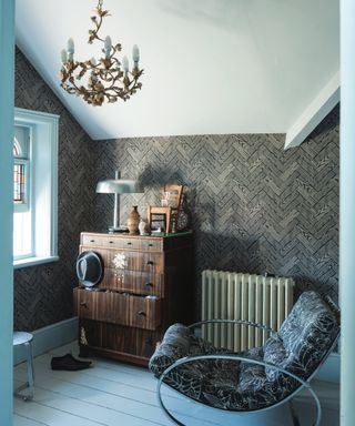 small corner of loft with vintage style furniture, chandelier light and darker wallpapered walls