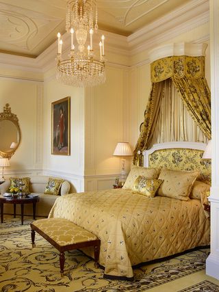 Ornate bedroom in gold tones with chandelier