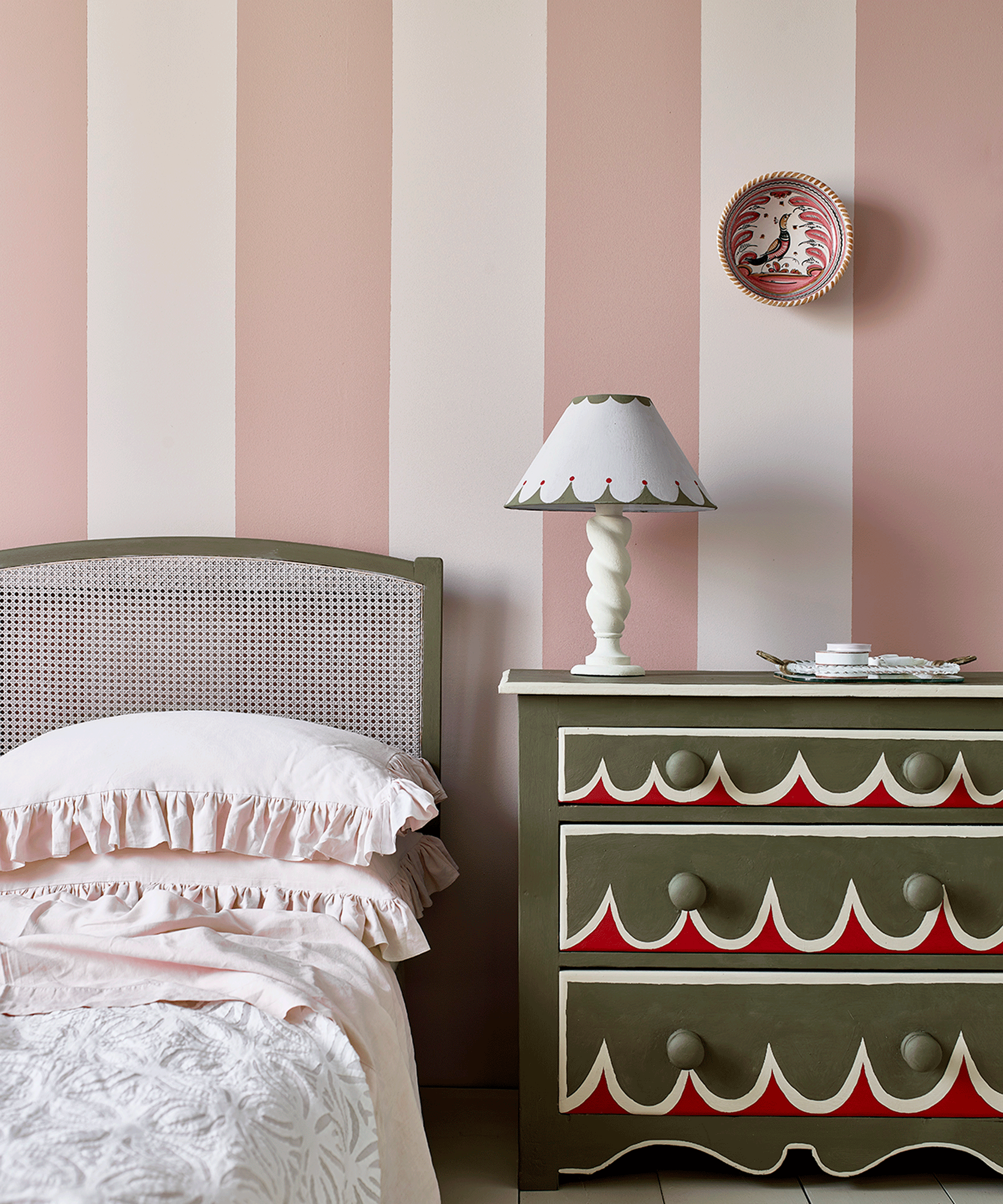 Bedroom with pink and white walls and patterned bedside table