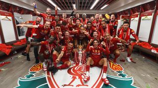 LIVERPOOL, ENGLAND - JULY 22: Trent Alexander-Arnold, Georginio Wijnaldum, Naby Keita, Roberto Firmino, Alex Oxlade-Chamberlain, Fabinho, Andy Robertson, Virgil van Dijk, James Milner, Joe Gomez, Curtis Jones, Adrian, Divock Origi, Adam Lallana, Harvey Elliott, Joel Matip, Xherdan Shaqiri, Jordan Henderson captain of Liverpool and Jurgen Klopp manager of Liverpool celebrating in the dressing room with the premier league trophy after winning the Premier league at the end of the Premier League match between Liverpool FC and Chelsea FC at Anfield on July 22, 2020 in Liverpool, England. Football Stadiums around Europe remain empty due to the Coronavirus Pandemic as Government social distancing laws prohibit fans inside venues resulting in all fixtures being played behind closed doors. (Photo by Andrew Powell/Liverpool FC via Getty Images)