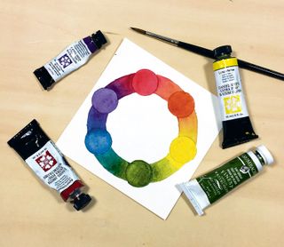 Watercolour colour wheel surrounded by corresponding paint tubes
