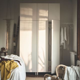 bedroom with white wardrobe and chairs