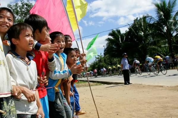 School children cheers on the racers as they speed by.