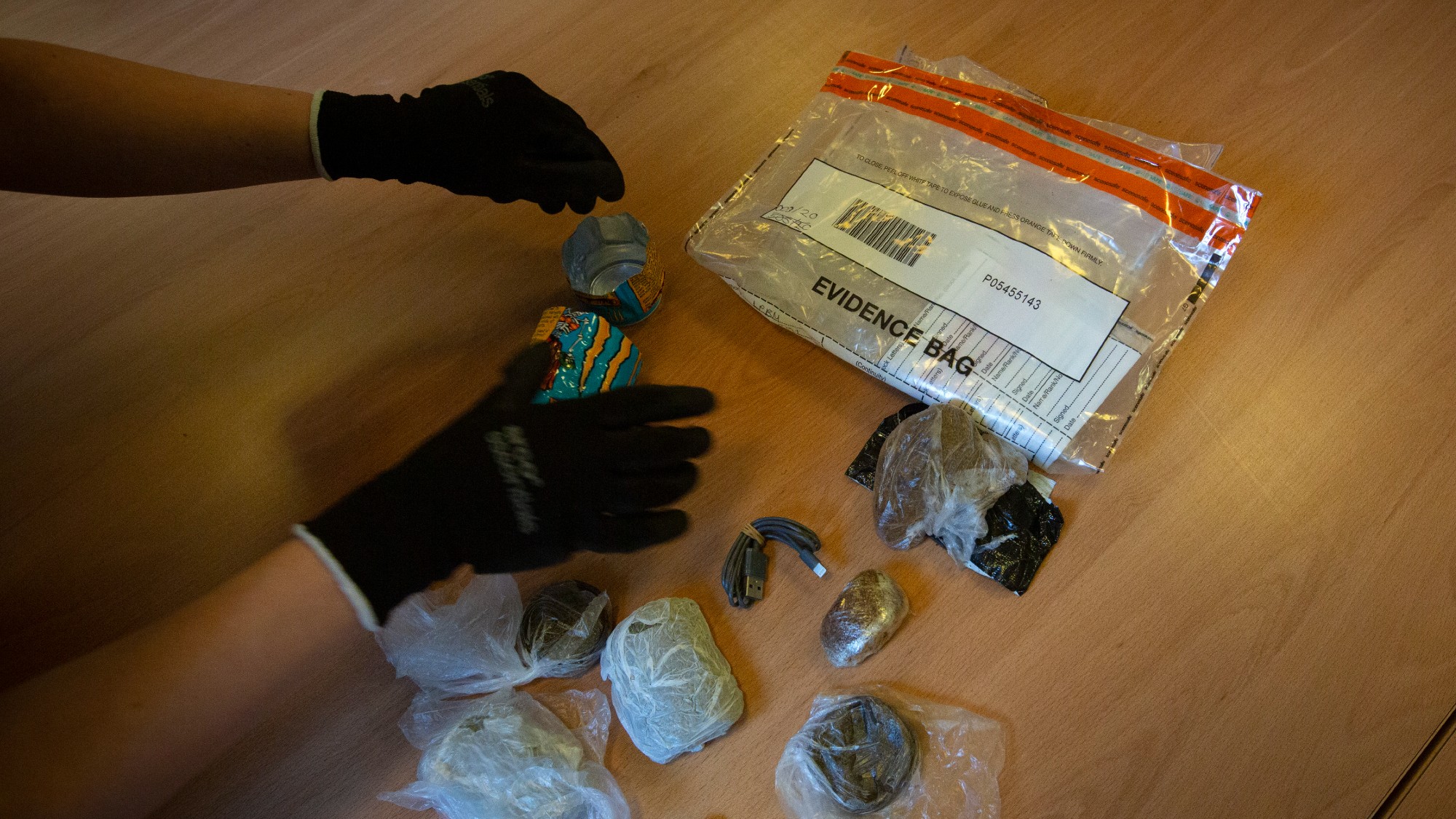 A prison officer examines confiscated items for drugs at HMP Liverpool