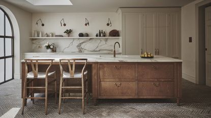 A modern minimalist kitchen with a large wood and marble island and open shelving over the sink