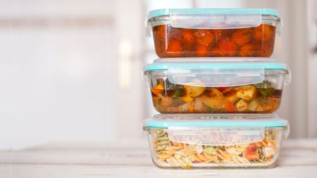 Stack of three tupperware boxes filled with food after a meal prepping session