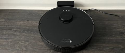 The Dreame Bot L10 Pro on its charger on hard wood floor
