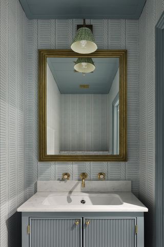 Powder room in soft blue with patterned wallpaper and reeded vanity unit by HAM Interiors