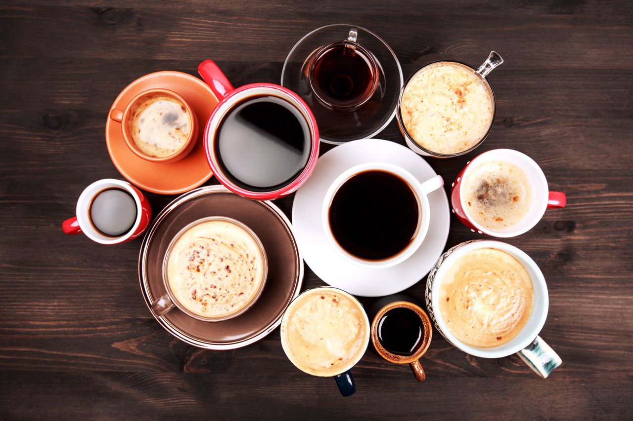 Many cups of coffee on wooden table.