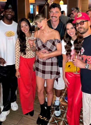 Taylor Swift stands with Travis Kelce at a Chiefs afterparty in a new pair of boots