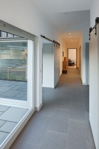 narrow hallway with large picture window and slate floor