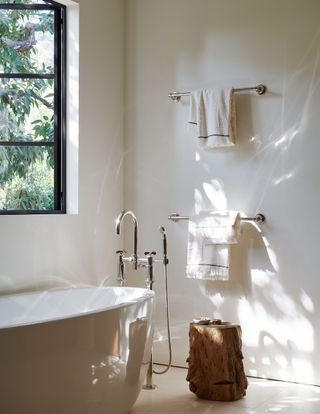 bathroom with freestanding bath white walls steel windows