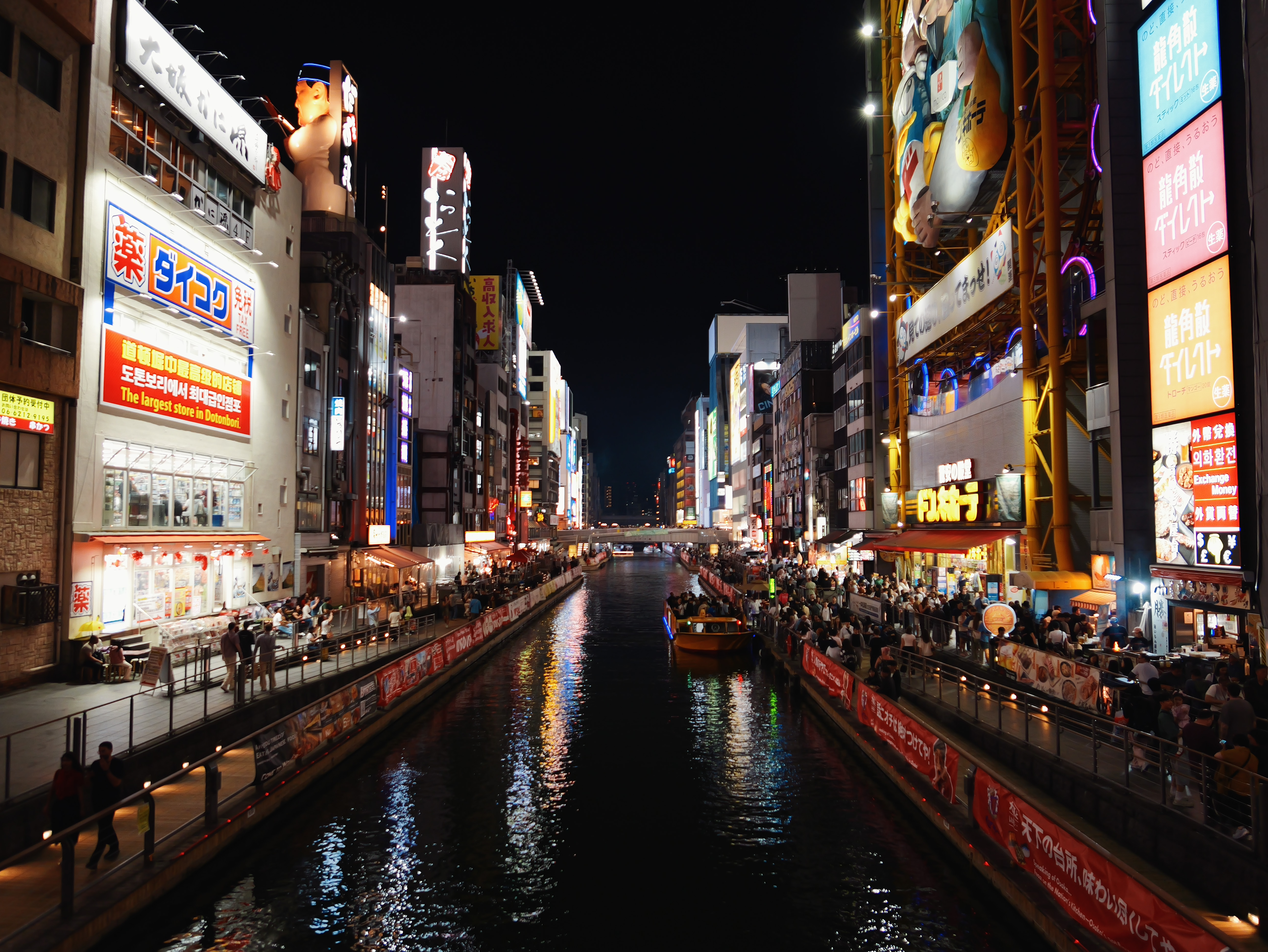 Night view of Osaka’s Dotonbori canal lined with illuminated signs.