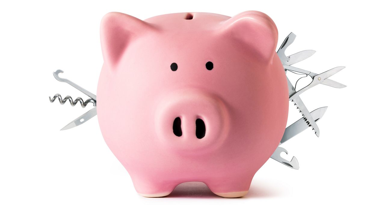 A piggy bank has multipurpose tools sticking out of it like it&#039;s a Swiss Army knife.