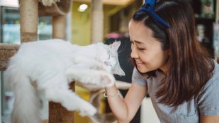 Smiling woman petting her cat