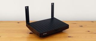 Linksys Hydra Pro 6 router on a wooden desk.