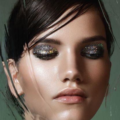 glitter eyeshadow - model with eyes closed and silver eyeshadow - gettyimages 667268691