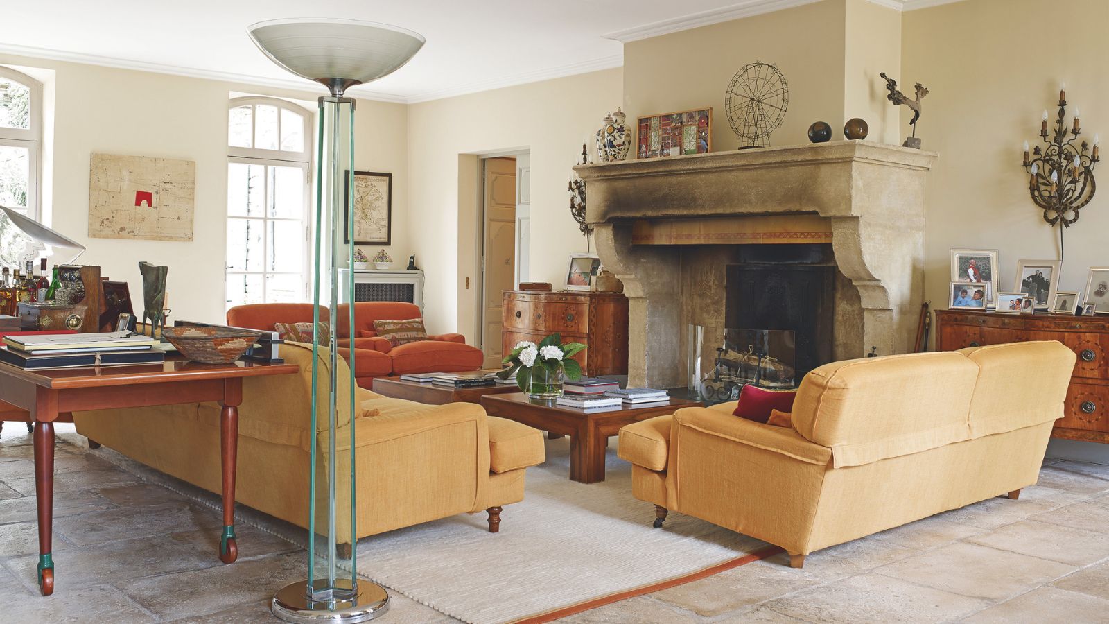 Lorenzo and Mariarosa Pellicioli home. Tan sofas, large period fireplace, assorted antique and modern furniture are pictured in large living room with beige/cream walls