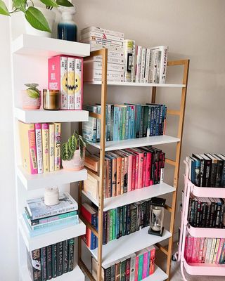 A set of three bookshelves with multicolored books on them