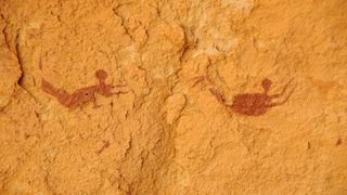 Rock art paintings depicting two people swimming. 