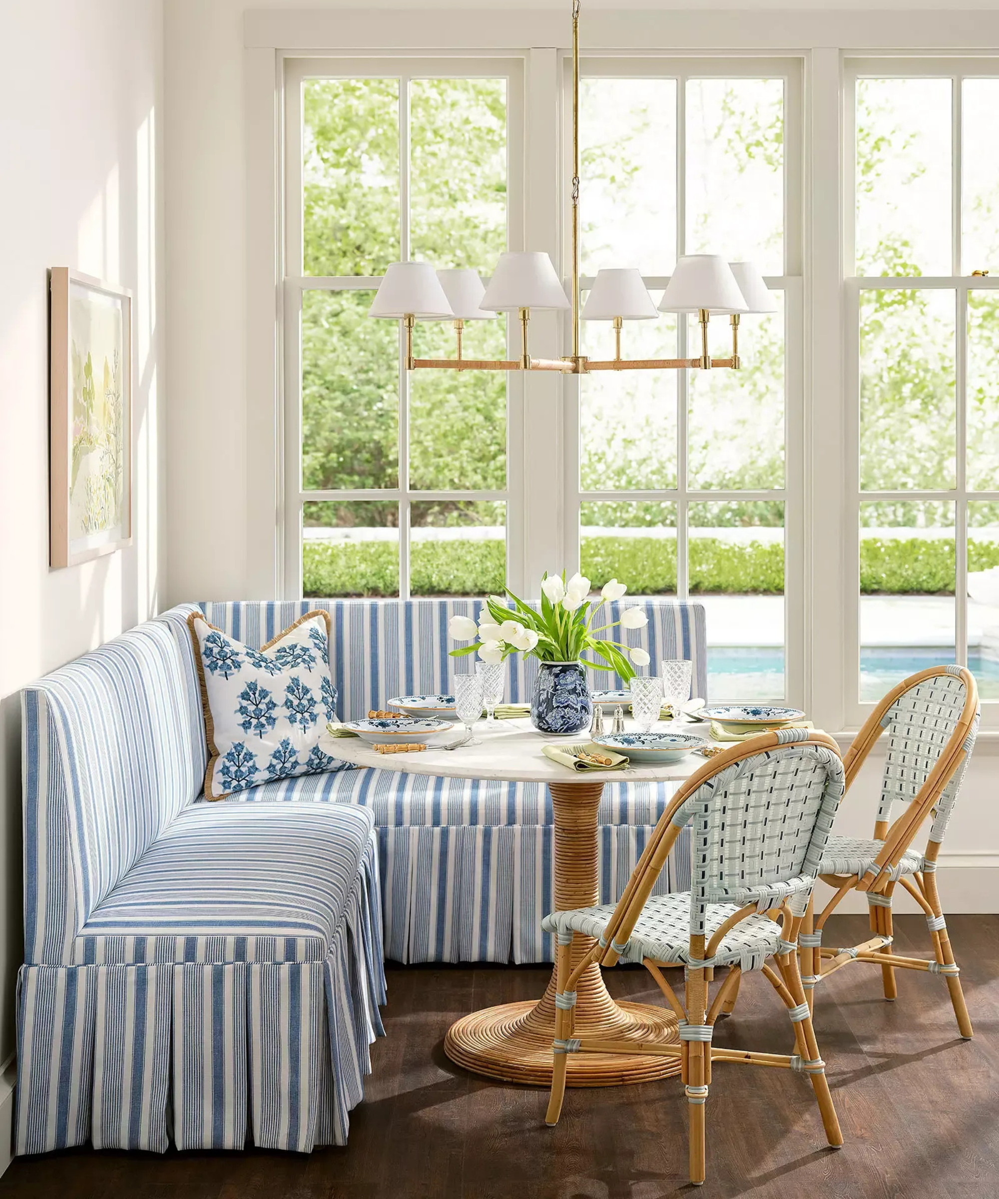 a dining nook with a striped banquette bench, two chairs, and a small round table
